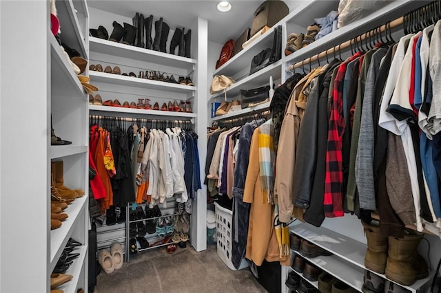 spacious closet with dark colored carpet