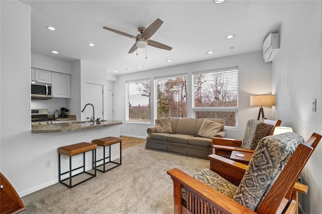 living room featuring light colored carpet, a wall unit AC, ceiling fan, and sink