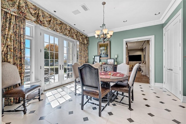 dining space with an inviting chandelier, crown molding, and french doors