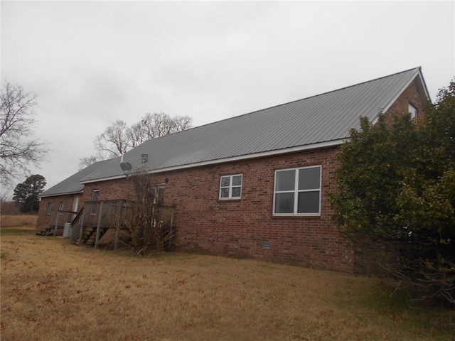 view of side of property with a wooden deck and a yard