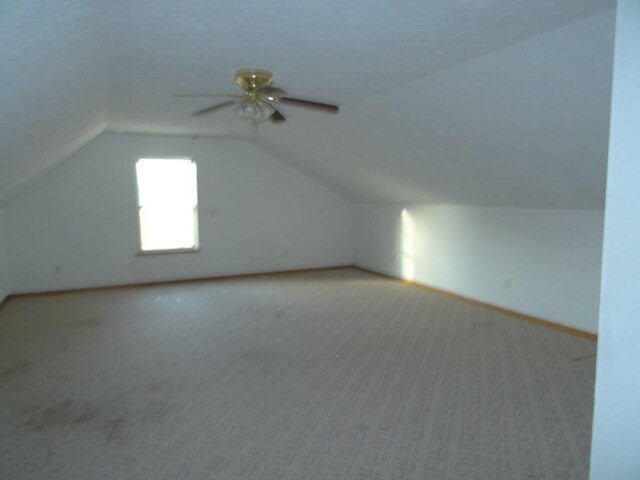 bonus room featuring ceiling fan, light carpet, and lofted ceiling