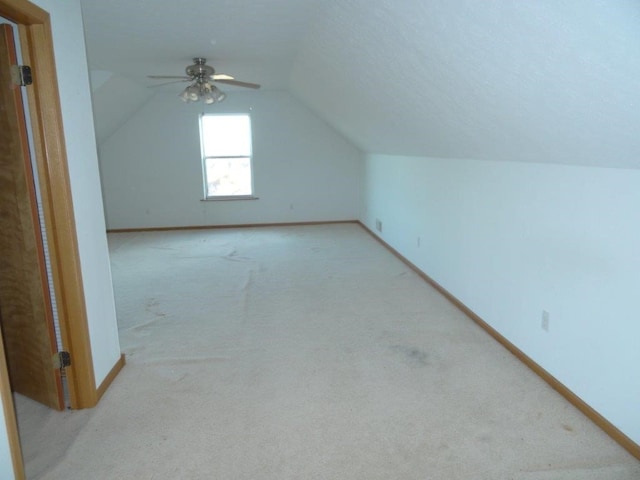 additional living space with light colored carpet, vaulted ceiling, and ceiling fan