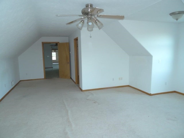 additional living space with ceiling fan, lofted ceiling, and light carpet