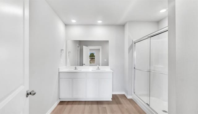 bathroom featuring walk in shower, vanity, and hardwood / wood-style flooring