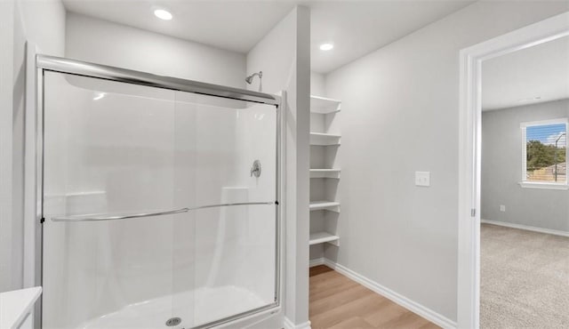 bathroom featuring hardwood / wood-style floors and walk in shower