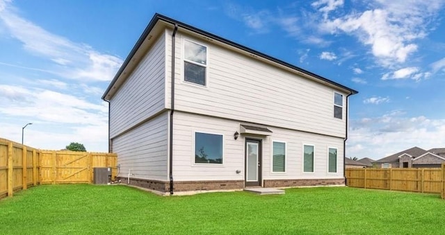 back of house featuring a yard and central air condition unit