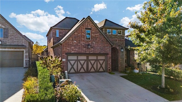 tudor home with a front yard and a garage