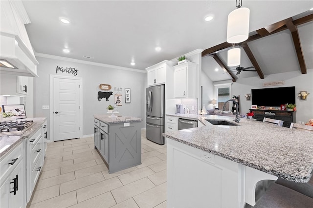 kitchen featuring a kitchen bar, appliances with stainless steel finishes, sink, white cabinetry, and a large island