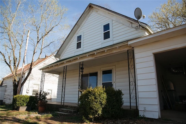 view of side of home featuring a porch and a garage