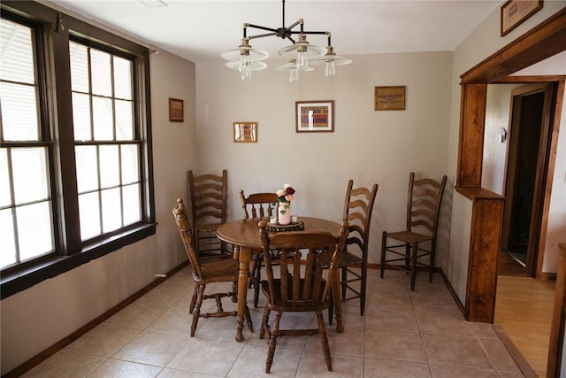 dining space featuring light tile patterned floors and a chandelier