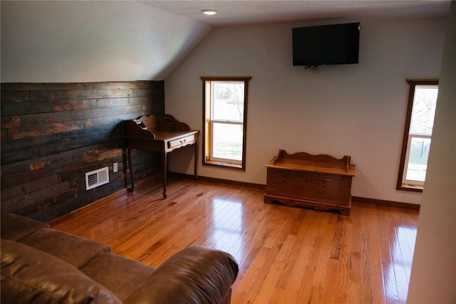 bonus room featuring plenty of natural light, lofted ceiling, and light hardwood / wood-style flooring