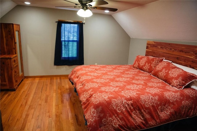 bedroom with ceiling fan, light wood-type flooring, and lofted ceiling