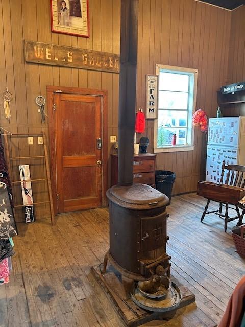 interior space featuring a wood stove, wood walls, and light hardwood / wood-style floors