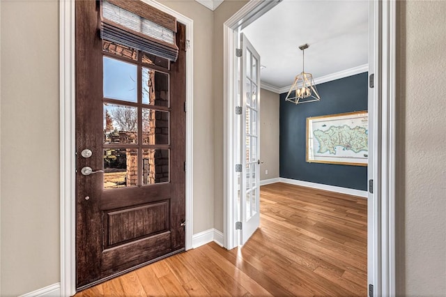 entryway featuring wood-type flooring and ornamental molding