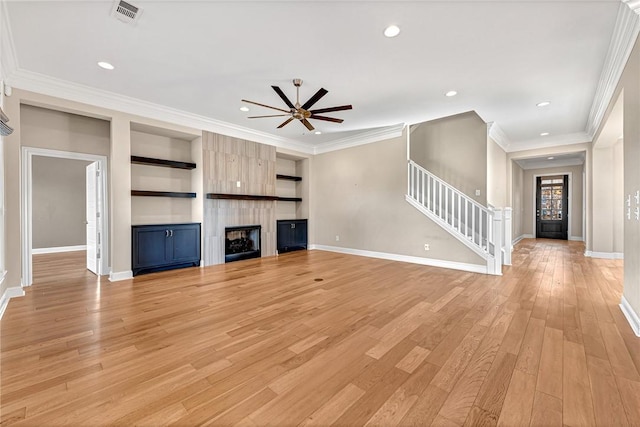 unfurnished living room with a large fireplace, light hardwood / wood-style flooring, ceiling fan, and ornamental molding