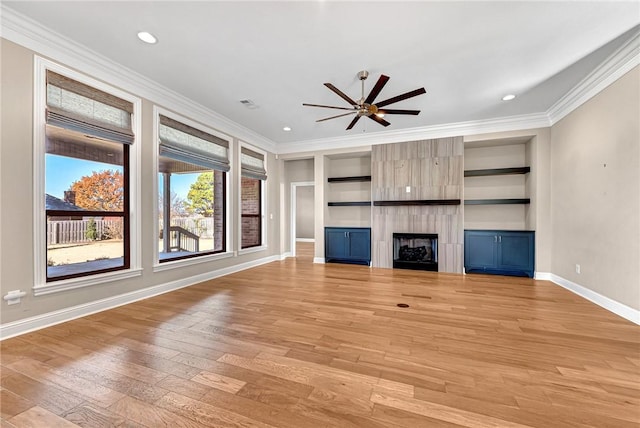 unfurnished living room with ceiling fan, built in features, light hardwood / wood-style flooring, crown molding, and a fireplace