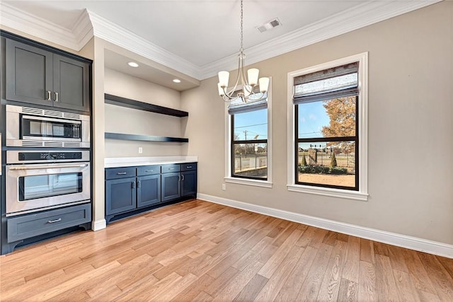 kitchen featuring light wood-type flooring, hanging light fixtures, appliances with stainless steel finishes, and a chandelier