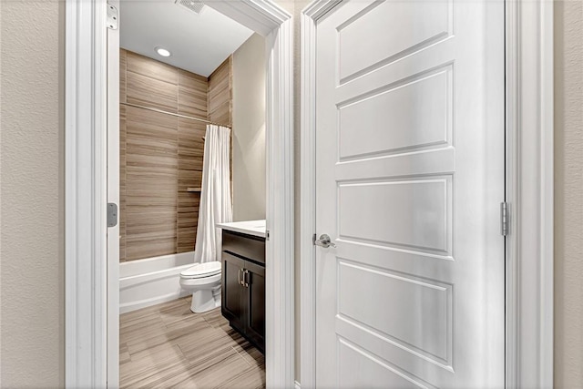 full bathroom featuring vanity, shower / bath combination with curtain, and toilet