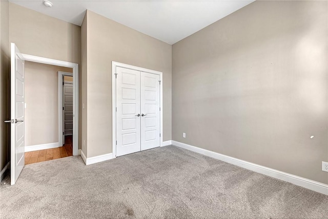 unfurnished bedroom with light carpet and a closet