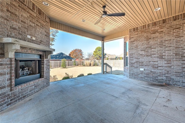 view of patio with an outdoor brick fireplace and ceiling fan