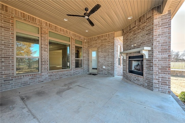 view of patio featuring an outdoor brick fireplace and ceiling fan