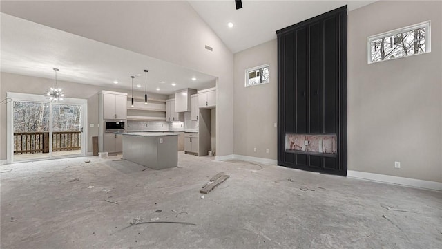 unfurnished living room featuring an inviting chandelier and high vaulted ceiling