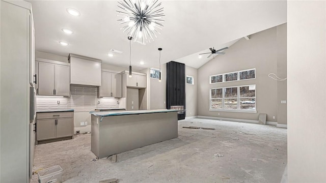 kitchen with tasteful backsplash, decorative light fixtures, a center island, high vaulted ceiling, and ceiling fan