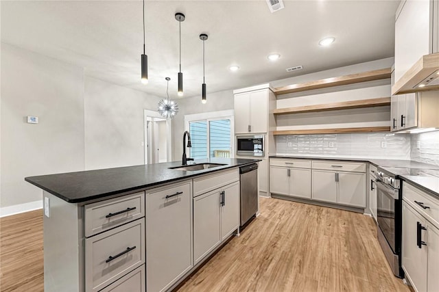 117 Kinross Dr, Bella Vista, AR 72715 - kitchen with stainless steel appliances, open shelves, custom exhaust hood, a center island with sink, and light wood finished floors