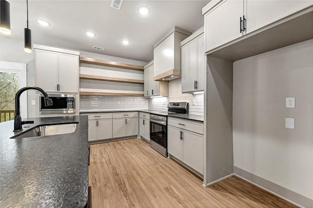 117 Kinross Dr, Bella Vista, AR 72715 - kitchen with stainless steel appliances, dark countertops, open shelves, backsplash, and light wood-style floors