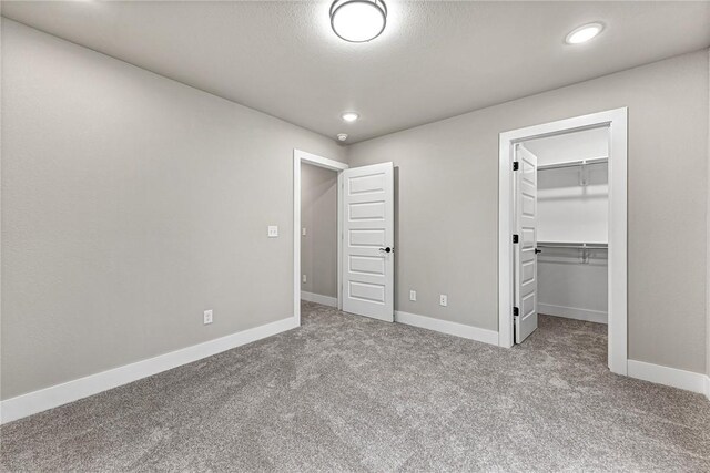 117 Kinross Dr, Bella Vista, AR 72715 - unfurnished bedroom featuring carpet flooring, a spacious closet, recessed lighting, and a closet