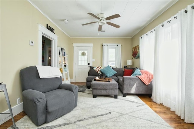 living area with crown molding, ceiling fan, and light hardwood / wood-style floors