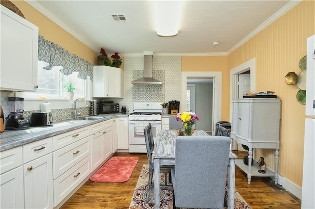 kitchen featuring wall chimney exhaust hood, dark wood-type flooring, backsplash, white cabinets, and white stove