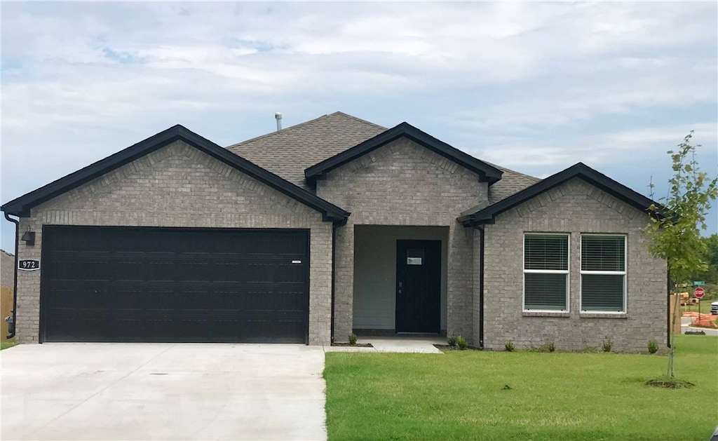 view of front of property featuring a garage and a front lawn