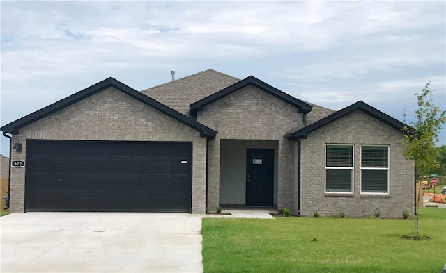 view of front of property featuring a garage and a front lawn