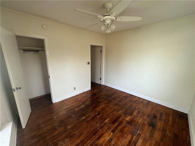 unfurnished bedroom featuring a closet, ceiling fan, dark hardwood / wood-style flooring, and crown molding