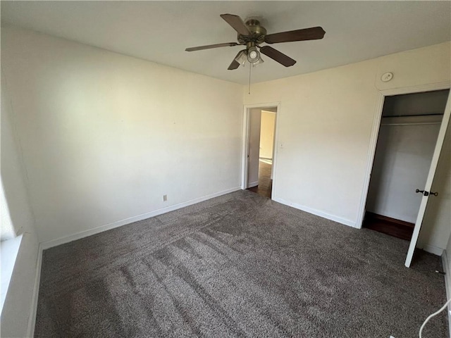 unfurnished bedroom featuring ceiling fan, dark carpet, and a closet
