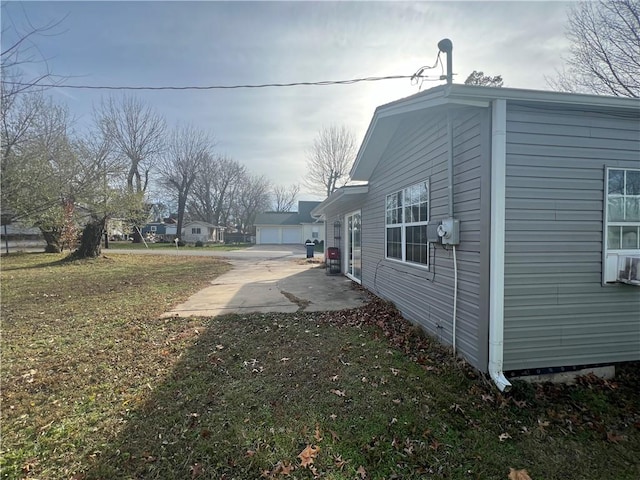 view of side of home featuring a garage and a yard