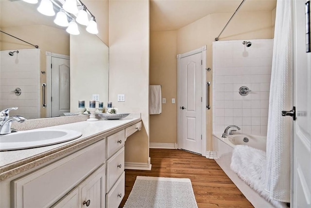 full bathroom featuring wood finished floors, vanity, baseboards, and shower / bath combo with shower curtain