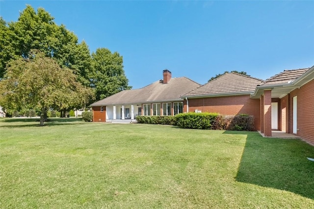 rear view of property with a lawn