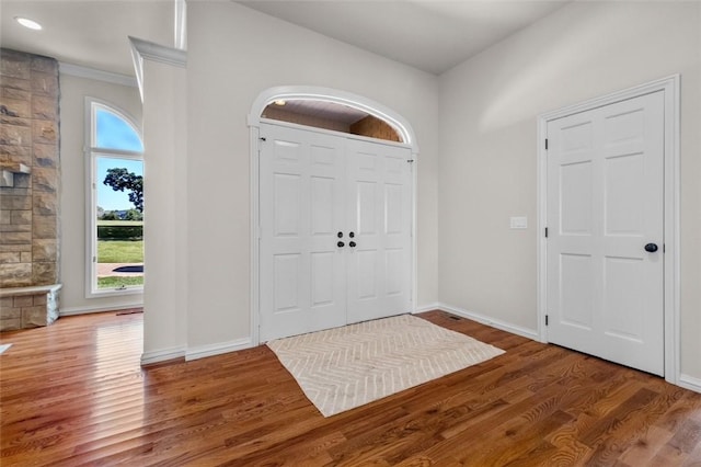 foyer with ornamental molding and hardwood / wood-style flooring