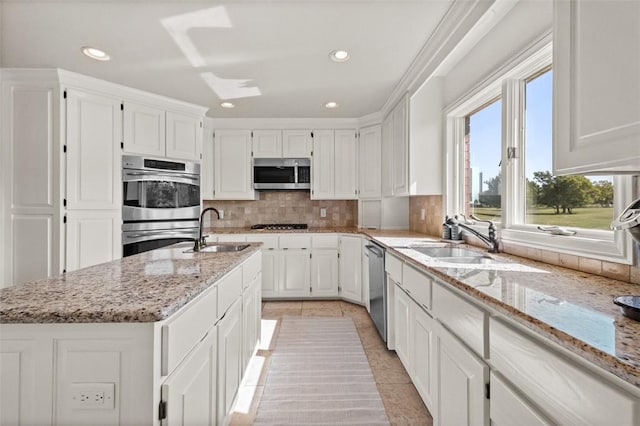 kitchen with white cabinets, light stone countertops, sink, and appliances with stainless steel finishes