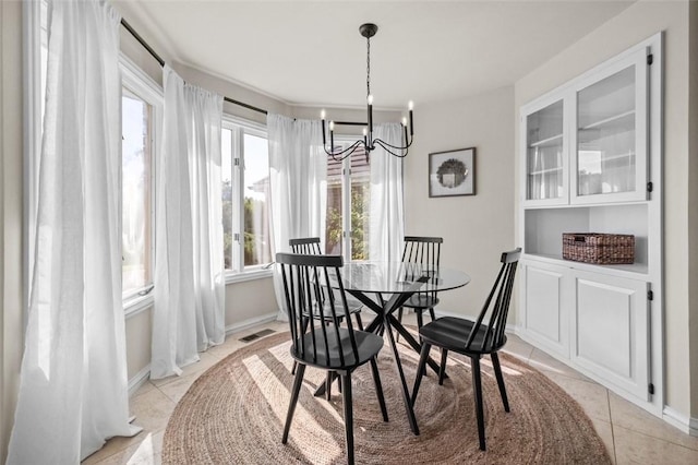 dining area featuring light tile patterned floors and an inviting chandelier