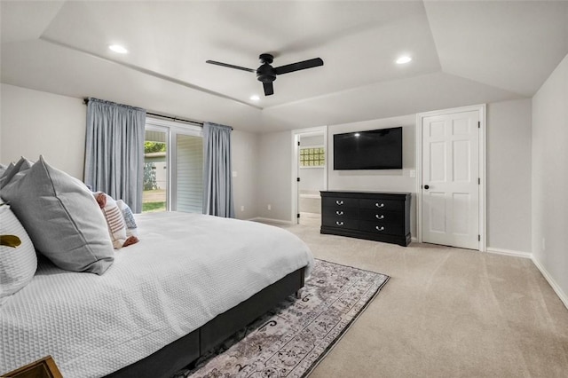 carpeted bedroom with connected bathroom, a raised ceiling, and ceiling fan