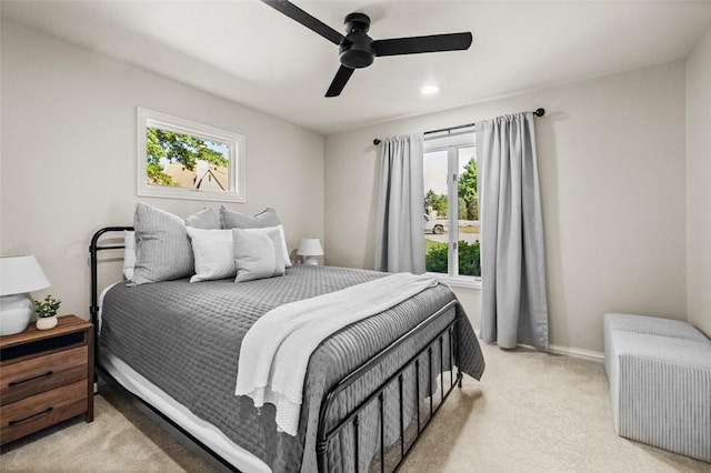 carpeted bedroom with multiple windows and ceiling fan