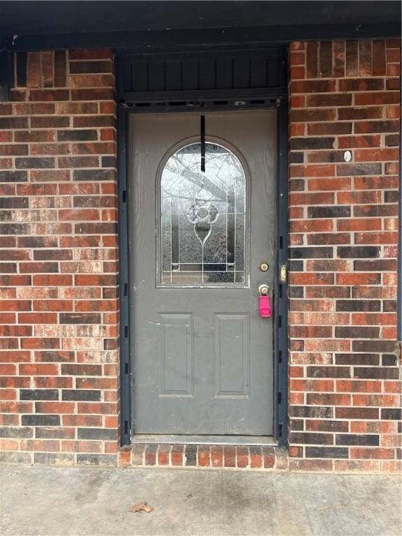 view of exterior entry with brick siding