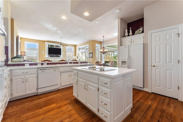 kitchen featuring white cabinets, white appliances, a kitchen island, and dark wood-type flooring