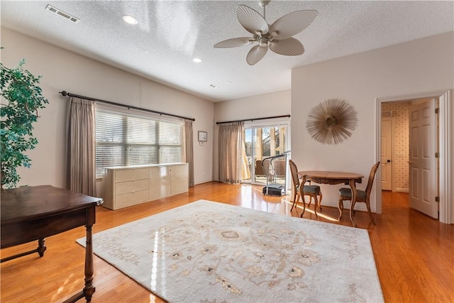 interior space with light wood-type flooring, a textured ceiling, and ceiling fan