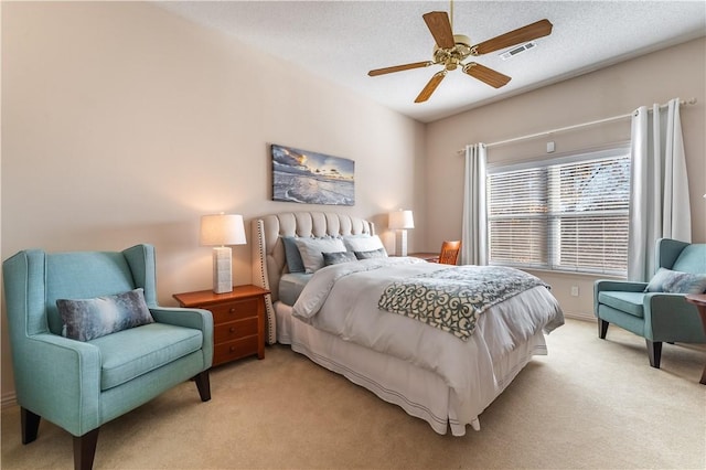 carpeted bedroom featuring a textured ceiling and ceiling fan