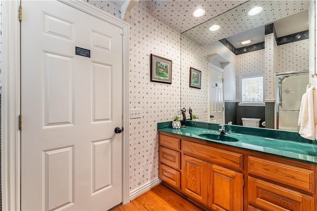 bathroom featuring an enclosed shower, vanity, toilet, and wood-type flooring