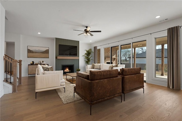 4201 88th St, Bentonville, AR 72718 - living area featuring a ceiling fan, wood finished floors, visible vents, and a fireplace